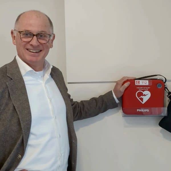 Mann montiert AED in Büro oder Flur